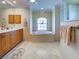 Spacious bathroom features a large soaking tub, a window for natural light, and tiled flooring at 237 Rotonda E Blvd, Rotonda West, FL 33947