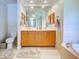 Bright bathroom features a toilet, dual sink vanity, with a large soaking tub nearby at 237 Rotonda E Blvd, Rotonda West, FL 33947