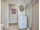 Full bathroom featuring a shower with glass doors, cabinet, toilet and a round mirror at 237 Rotonda E Blvd, Rotonda West, FL 33947
