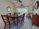 Bright dining room boasts a large wooden table, seating for six, and a view of the pool and patio at 237 Rotonda E Blvd, Rotonda West, FL 33947