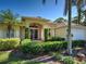 Elegant home exterior featuring manicured shrubs, glass front door and arched entryway at 237 Rotonda E Blvd, Rotonda West, FL 33947