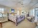Comfortable primary bedroom features a ceiling fan, dresser, and a sitting chair with lots of natural light at 237 Rotonda E Blvd, Rotonda West, FL 33947