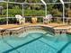 Tranquil screened-in pool with seating, water features, and lush greenery create a private oasis at 237 Rotonda E Blvd, Rotonda West, FL 33947