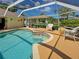 Inviting pool area under a screened enclosure, surrounded by lush greenery and outdoor seating at 237 Rotonda E Blvd, Rotonda West, FL 33947