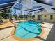 Beautiful screened-in pool offers a serene backyard retreat with mature trees and clear blue water at 237 Rotonda E Blvd, Rotonda West, FL 33947