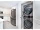 Modern kitchen with adjacent laundry featuring stainless appliances and white cabinets at 2700 N Beach Rd # A201, Englewood, FL 34223