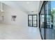 A bright room with tall ceilings, sliding glass doors to an outdoor balcony and views of palm trees at 2700 N Beach Rd # A201, Englewood, FL 34223