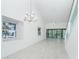 Open concept living area with high ceilings, modern chandelier, and access to the outdoor balcony at 2700 N Beach Rd # A201, Englewood, FL 34223