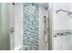 Modern glass shower boasting blue mosaic tiles, sleek fixtures, and corner shelf at 2700 N Beach Rd # A201, Englewood, FL 34223