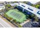 Aerial view of well-maintained tennis court with lush landscaping and adjacent parking for residents at 2700 N Beach Rd # A201, Englewood, FL 34223