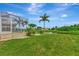 A beautiful green backyard with a screened-in lanai with a pool and a view of a serene pond at 29 Tournament Rd, Rotonda West, FL 33947