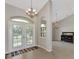 Welcoming foyer featuring tile flooring and neutral walls, complemented by a stylish chandelier and transom window at 29 Tournament Rd, Rotonda West, FL 33947