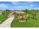 Stunning single-Gathering home with a well-manicured lawn and lush landscaping, including mature palm trees at 29 Tournament Rd, Rotonda West, FL 33947