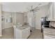 Open kitchen design with stone countertops, white cabinets, bar seating, and stainless steel appliances at 29 Tournament Rd, Rotonda West, FL 33947