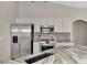Modern kitchen featuring stainless steel appliances, stone backsplash, granite counters, and a curved sink at 29 Tournament Rd, Rotonda West, FL 33947