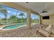 Relaxing lanai with pool, ceiling fan, brick floors, and comfortable seating area at 29 Tournament Rd, Rotonda West, FL 33947