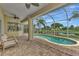 Relaxing lanai with pool, ceiling fan, brick floors, and comfortable seating area at 29 Tournament Rd, Rotonda West, FL 33947