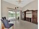 Bright living room with tile flooring, dark wood entertainment center and sliding doors to screened patio at 29 Tournament Rd, Rotonda West, FL 33947