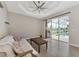 Living room boasts neutral walls, tile floors, and sliding glass doors that lead to a screened-in pool area at 29 Tournament Rd, Rotonda West, FL 33947