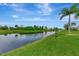 A tranquil waterway flows through a lush green landscape, reflecting the blue sky and scattered clouds at 29 Tournament Rd, Rotonda West, FL 33947