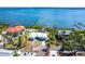 Picturesque aerial shot of a light blue home with a white roof and a dock surrounded by lush tropical trees at 4093 Pelican Shores Cir, Englewood, FL 34223