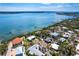 Breathtaking aerial view of a light blue home near the serene waters and an abundance of lush, tropical trees at 4093 Pelican Shores Cir, Englewood, FL 34223