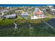 Stunning aerial view showcases a light blue home with a dock against the backdrop of sparkling ocean waters at 4093 Pelican Shores Cir, Englewood, FL 34223