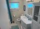 Clean bathroom featuring a vanity with drawers, toilet, mirror, and shower with blue curtain at 4093 Pelican Shores Cir, Englewood, FL 34223