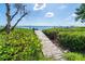 Scenic view of a wooden dock leading to the tranquil waters, surrounded by vibrant foliage at 4093 Pelican Shores Cir, Englewood, FL 34223