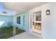 Covered porch leading into a house with aqua colored siding and white trim. Interior is in need of repair at 4093 Pelican Shores Cir, Englewood, FL 34223