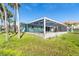 Exterior view showcases a screened pool and ample green space offering a private outdoor retreat at 4093 Pelican Shores Cir, Englewood, FL 34223