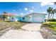 Inviting light blue single-story home featuring an attached garage, complemented by its location near the water at 4093 Pelican Shores Cir, Englewood, FL 34223