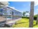 Screened pool with water view and landscaped backyard, perfect for entertaining and relaxation at 4093 Pelican Shores Cir, Englewood, FL 34223