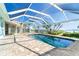 Sparkling pool in an enclosed patio featuring scenic views of a tranquil bay with clear blue skies at 4093 Pelican Shores Cir, Englewood, FL 34223