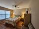A cozy bedroom offers a comfortable bed, ceiling fan, and natural light from a large window at 4260 Placida Rd # 21C, Englewood, FL 34224