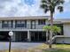 Two story condo with covered parking, palm tree, and well maintained lawn at 4260 Placida Rd # 21C, Englewood, FL 34224