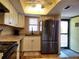 Bright kitchen offers stainless steel refrigerator, white cabinets, and a view to the lanai at 4260 Placida Rd # 21C, Englewood, FL 34224
