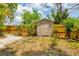 Backyard view showcasing a wooden fence and small storage shed set amongst some plants and a gravel area at 5250 Callaway St, Port Charlotte, FL 33981