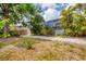 Spacious backyard with a screened-in pool area, mature trees, a wooden fence, and a pea gravel ground cover at 5250 Callaway St, Port Charlotte, FL 33981