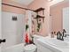 Bright bathroom with a shower/tub combo, stylish curtain, and modern shelving for storage at 5250 Callaway St, Port Charlotte, FL 33981