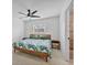 Modern bedroom with ceiling fan, stylish bed frame, and ensuite bathroom with a tiled shower at 5250 Callaway St, Port Charlotte, FL 33981