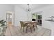 Sunlit dining area with modern lighting fixture, sliding glass doors to the lanai, and stylish furniture at 5250 Callaway St, Port Charlotte, FL 33981