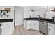 Bright kitchen features white cabinetry, sleek black countertops and modern stainless steel dishwasher at 5250 Callaway St, Port Charlotte, FL 33981