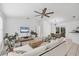 Bright living room featuring neutral decor, a ceiling fan, a comfortable sofa, and stylish furniture at 5250 Callaway St, Port Charlotte, FL 33981
