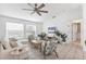 Well-lit living room featuring neutral decor, a ceiling fan, comfortable sofa, stylish furniture, and many windows at 5250 Callaway St, Port Charlotte, FL 33981