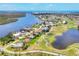 Aerial view of golf community featuring lake, golf course and surrounding waterways at 585 Coral Creek Dr, Placida, FL 33946
