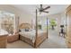 Bedroom with four-poster bed, a ceiling fan, and large windows overlooking the property at 585 Coral Creek Dr, Placida, FL 33946