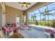 Large, covered patio with comfortable seating, screened enclosure, and peaceful golf course view at 585 Coral Creek Dr, Placida, FL 33946