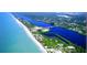 Aerial view of the coastline, showing beaches, waterways, and surrounding residential area at 5879 Venisota Rd, Venice, FL 34293