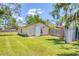 A verdant backyard provides a detached structure and is surrounded by a wood privacy fence at 5879 Venisota Rd, Venice, FL 34293